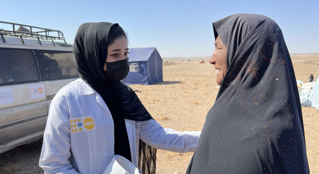 Faiza Sarie (left) is a psychosocial counsellor deployed to support a mobile health team. She comforts a woman from Zindajan who lost family members during the earthquake. 