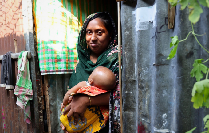 A photo of a mother carrying her infant at a remote village in Bangladesh