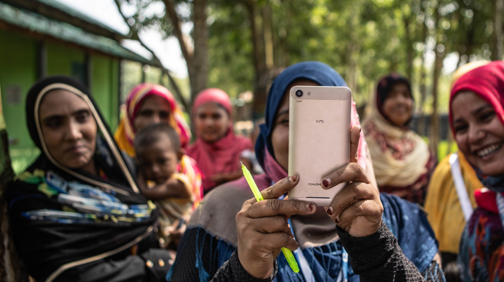 Ladies in Cox's Bazar look into a mobile phone