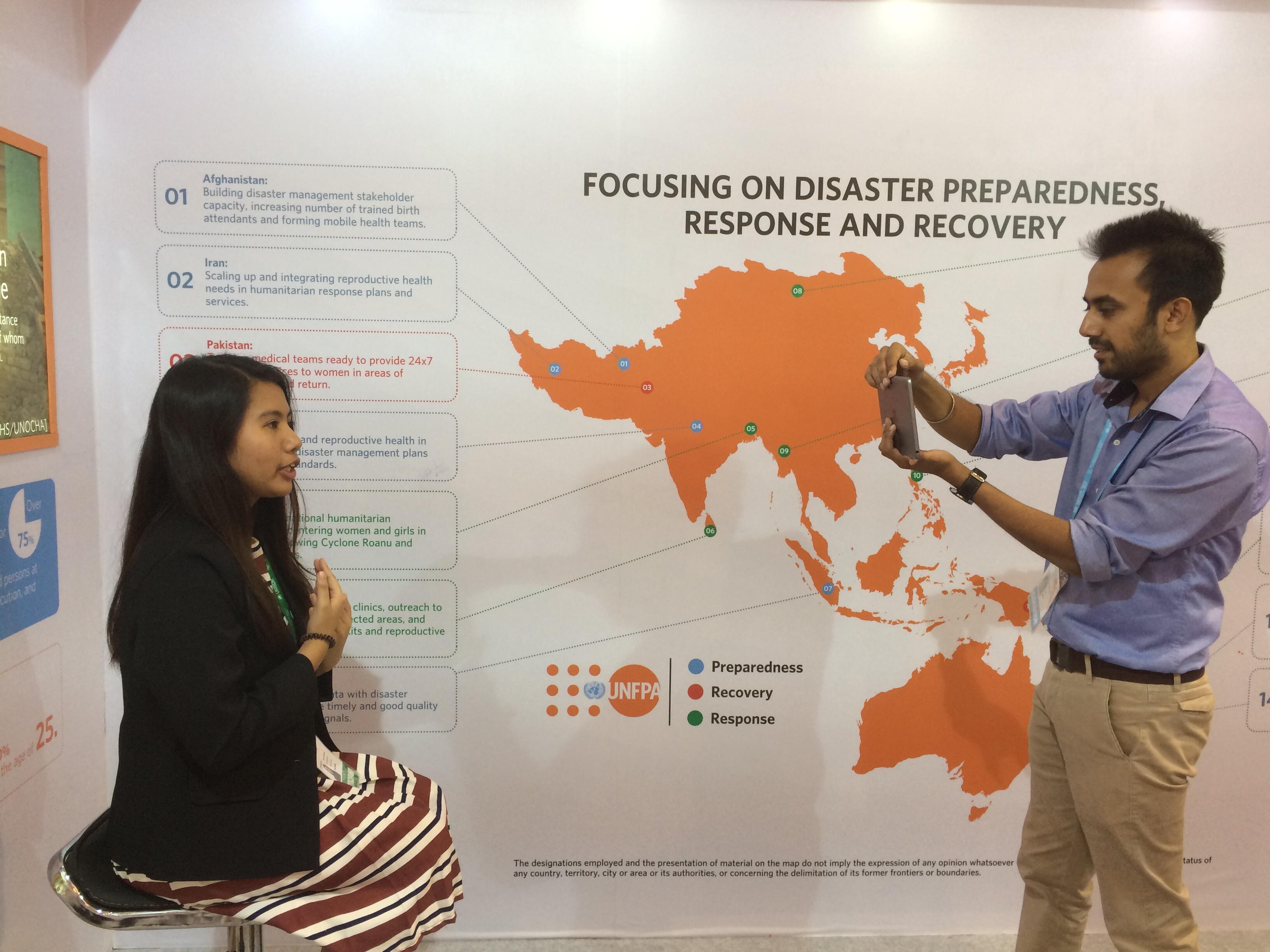 Chloe Reynaldo being interviewed at the UNFPA AMCDRR stall