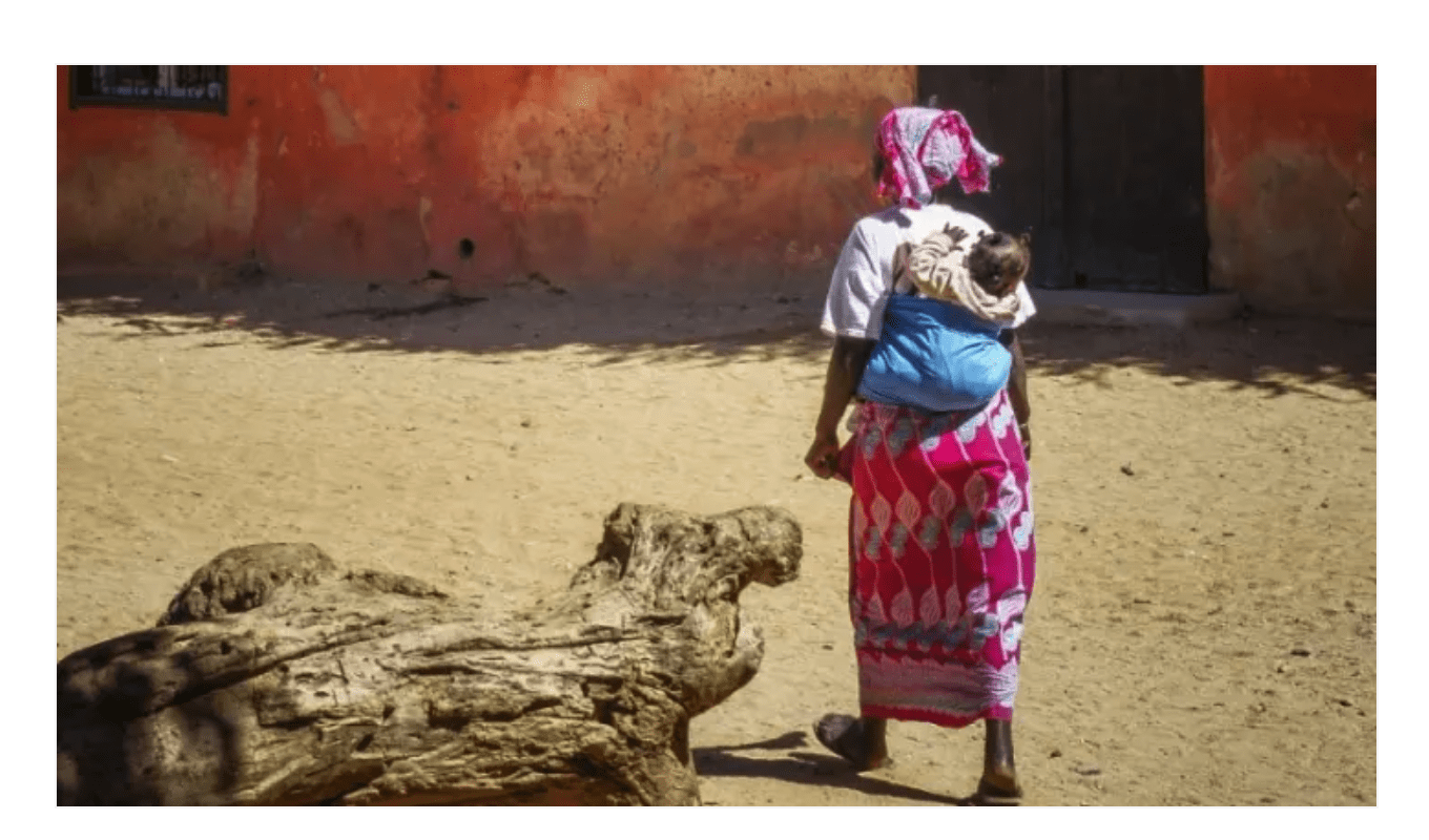 A woman walks with her baby in Dakar, Senegal. Photo by: Vince Gx on Unsplash