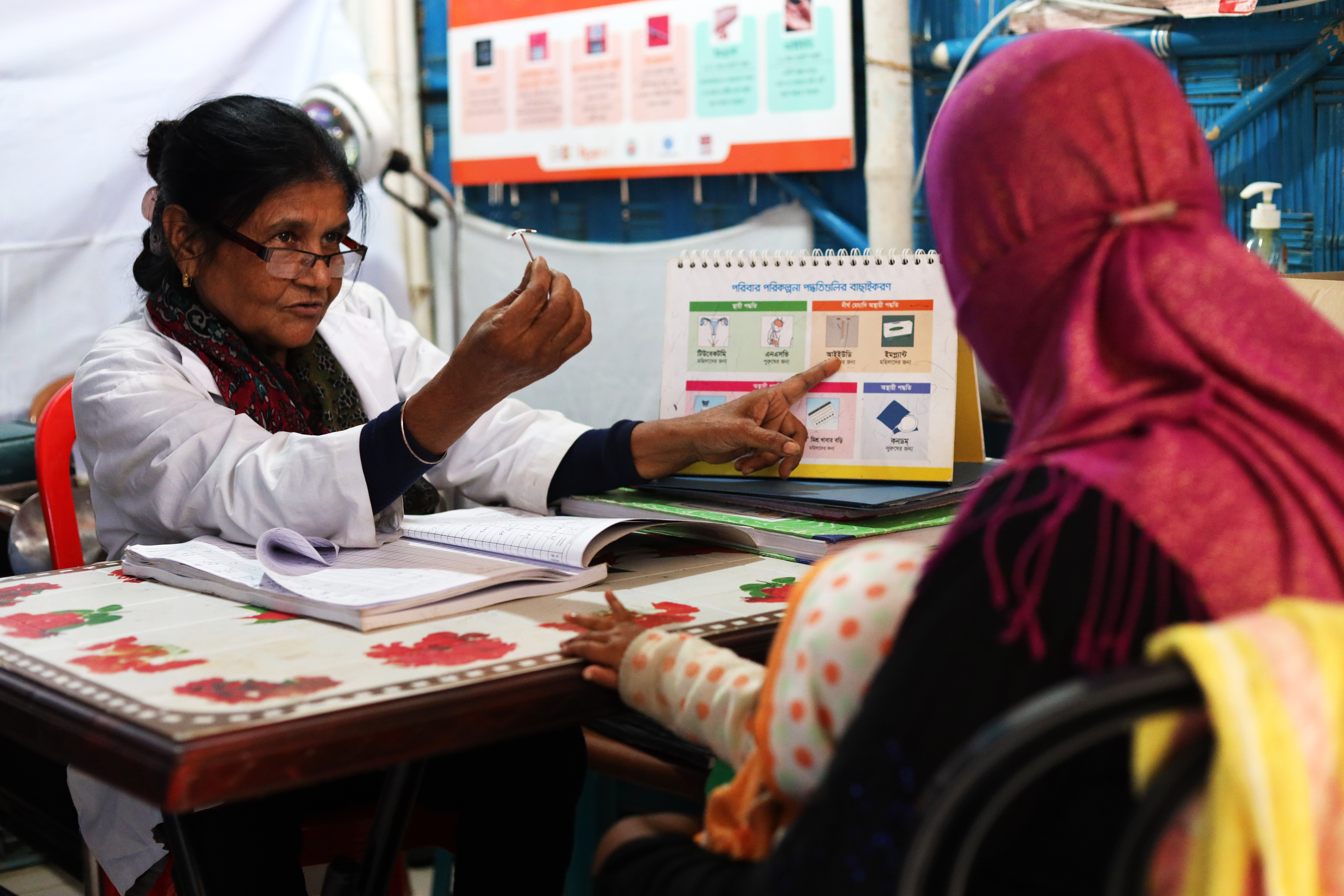 A healthcare worker in Cox's Bazar, Bangladesh, provides family planning information to a young mother
